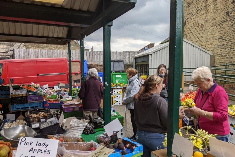 a busy market with several stalls and customers